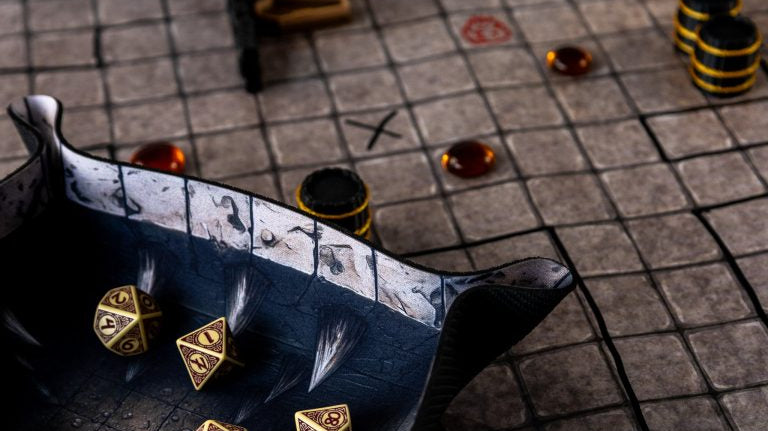 RPG mat with a square grid, terrain pieces and markers, with gold-coloured dice in a fantasy-themed dice tray.